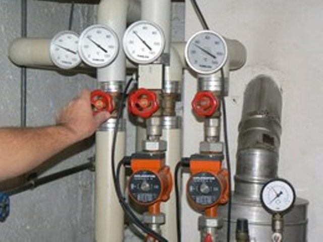 Zuleitungen zu Heizungen mit Thermometeranzeigen und Vorlaufpumpen.