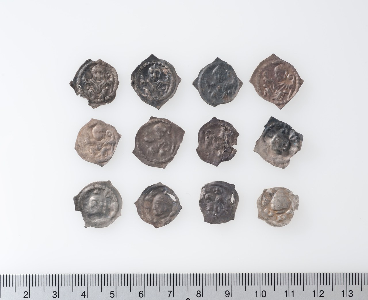 Bild 1: Zwölf Silberpfennige, um 1275 bis frühes 14. Jahrhundert. Prägungen des Bistums Basel, der Fraumünsterabtei Zürich sowie der Städte Solothurn und Schaffhausen. Fundort: Morgarten ZG