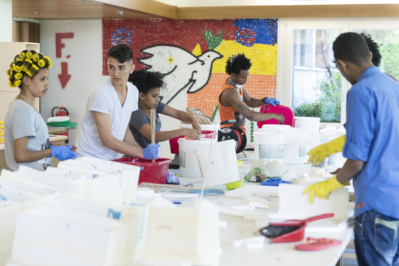 Junge Asylsuchende im Jugendwohnheim Waldheim bei der Arbeit am Kunstwerk «Unterwegs», eine aus Gipsfüssen bestehende Installation.