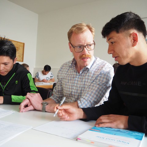 Foto 3 Regierungsrat Hostettler lernt mit Danishjo und Ahmadi.jpg