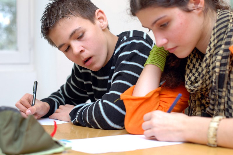 Schüler und Schülerin arbeitend an je einem Arbeitsblatt