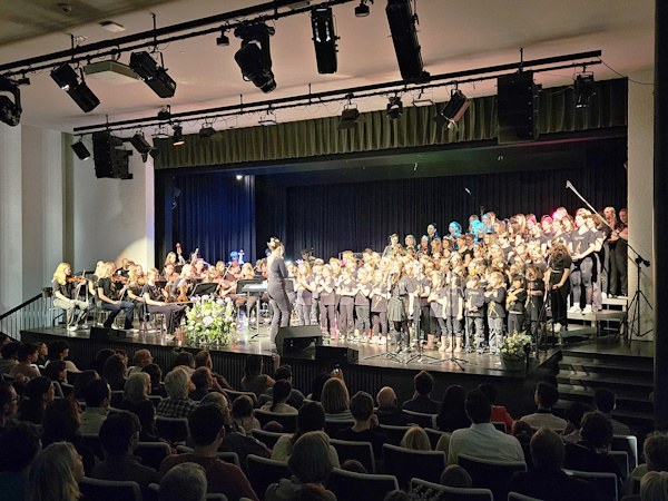 110 Sängerinnen und Sänger, Musikerinnen und Musiker geben zum Takt der Dirigentin ihr Bestes.